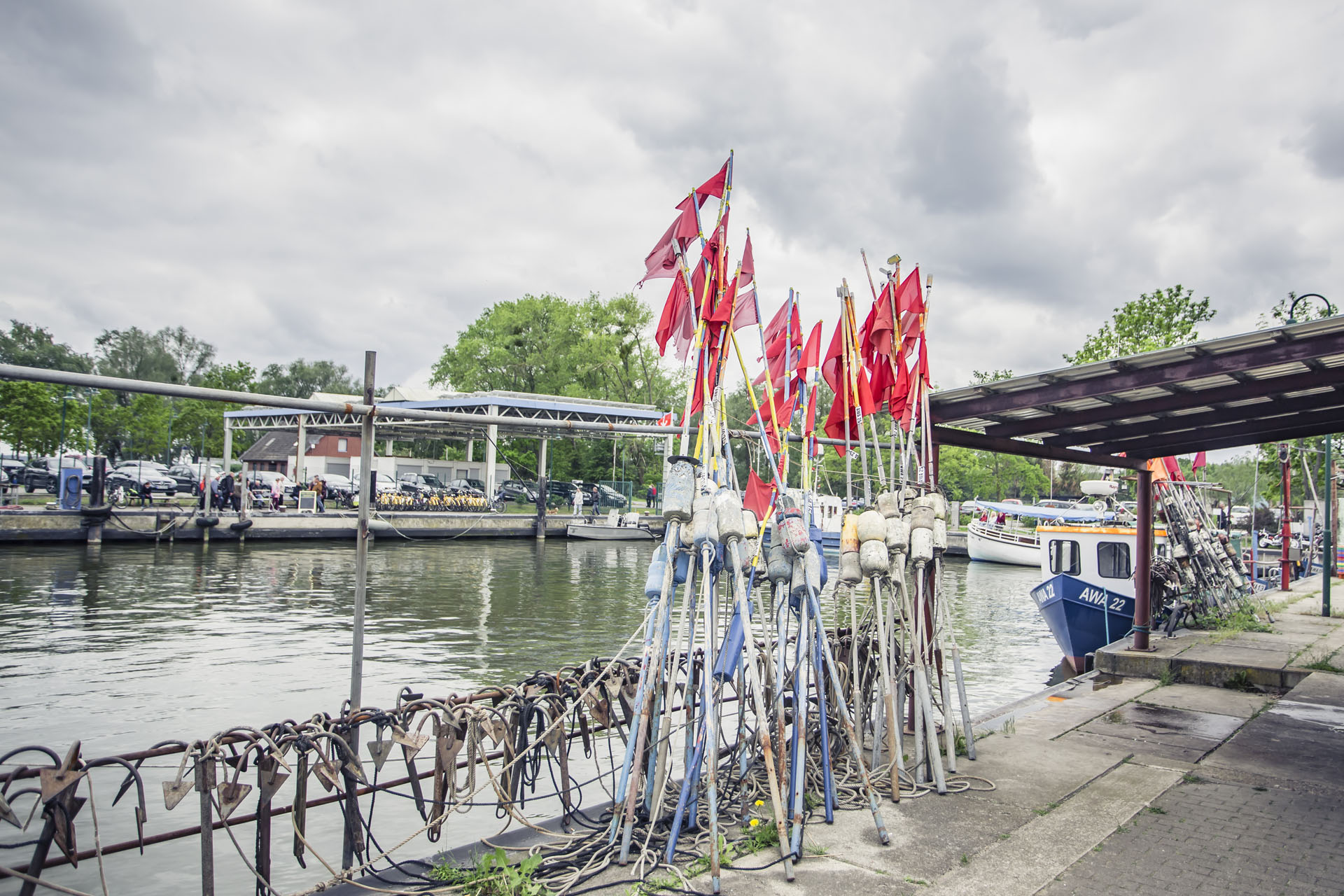 Rote Fischerfahnen und Anker am Hafen von Altwarp mit Booten im Hintergrund